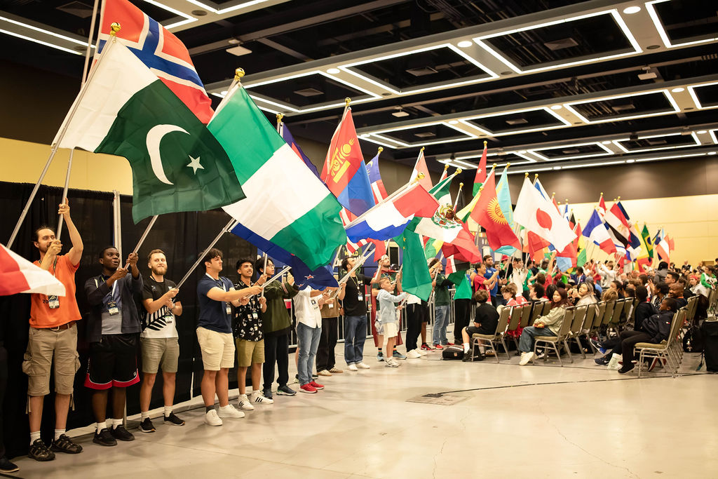 A picture from the 2025 World Championship opening ceremony, with cubers holding flags from different countries standing in a line