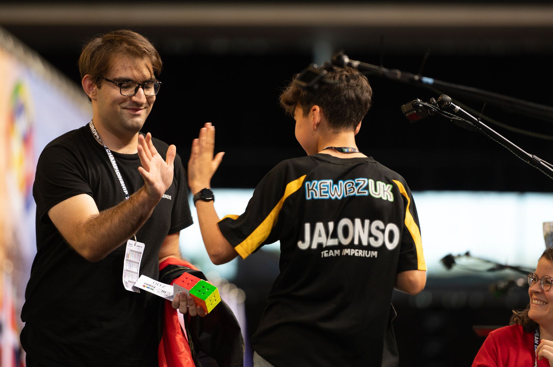 A smiling staff member and competitor high-fiving